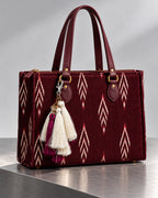 Gulal silk tassel charm clipped to the Ruby Ikat Red Laptop Tote Bag