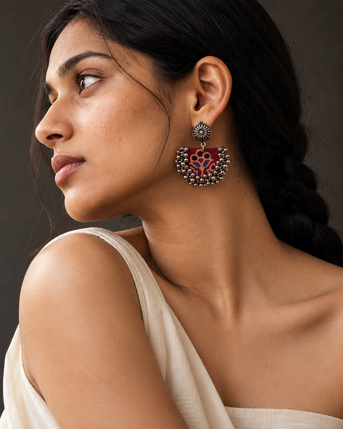 Maroon Chandbali Earrings with Ghungroo in profile with a cream drape and a braid: deep red block-printed crescent with a floral motif, kundan stud and silver ghungroo bells