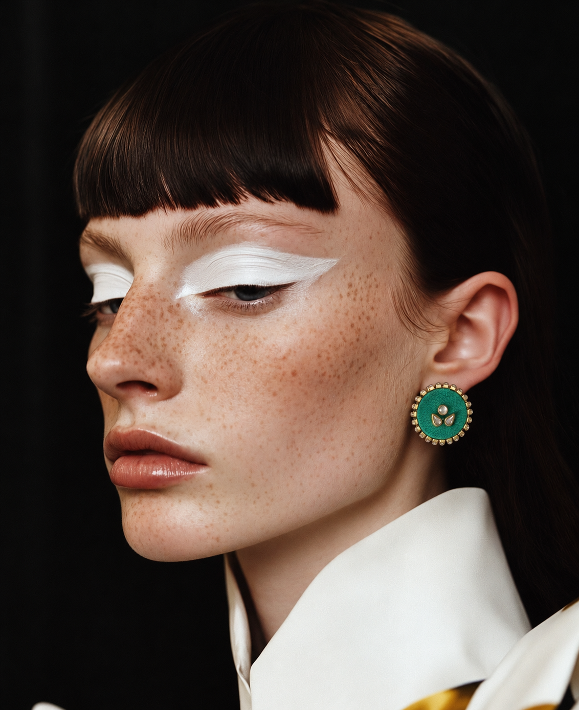 Close-up of the Mogra mint green kundan stud with bold white eye make-up and a white collar