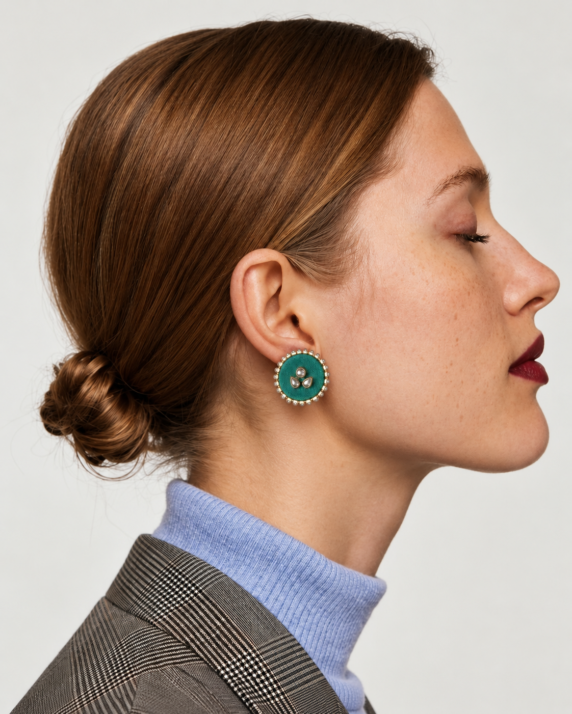 Mint green round kundan stud earring in profile, worn with a grey check blazer and a lilac roll neck