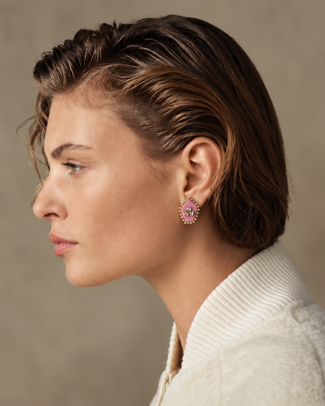 Mogra Pink Pentagon Kundan Studs in profile with slicked-back hair and an ivory jacket: three kundan stones on pink fabric, edged with small kundan