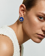 Royal blue round kundan stud earring seen up close with a white textured top