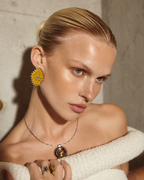 Mogra Yellow Pentagon Kundan Studs worn with an ivory knit and a pendant: three kundan stones on yellow fabric, edged with small kundan