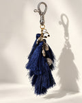 Nisha silk tassel bag charm: silver-tone coins and one small black-and-white panda at the head. It hangs from a silver-tone swivel clasp.