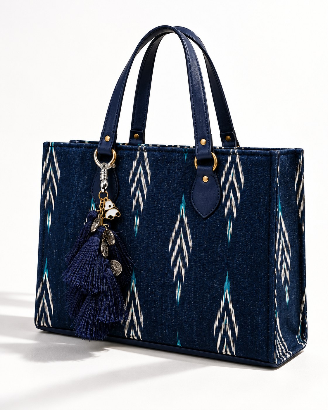 Nisha silk tassel charm clipped to the Midnight Ikat Laptop Tote Bag, Navy