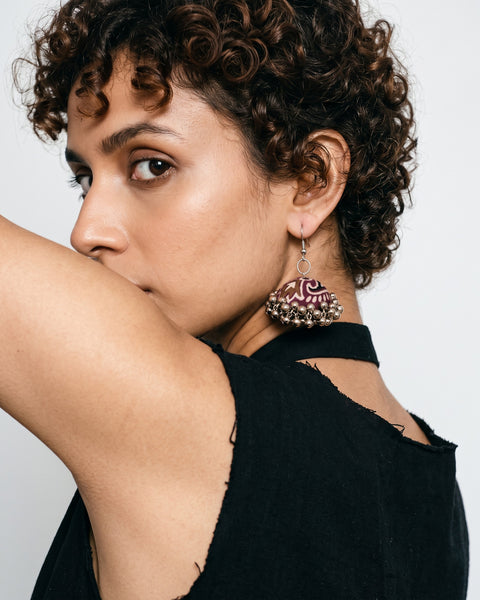 Neel Kamal Jhumka Earrings worn on a model with curly hair, bone-white studio (AI-generated styling image)