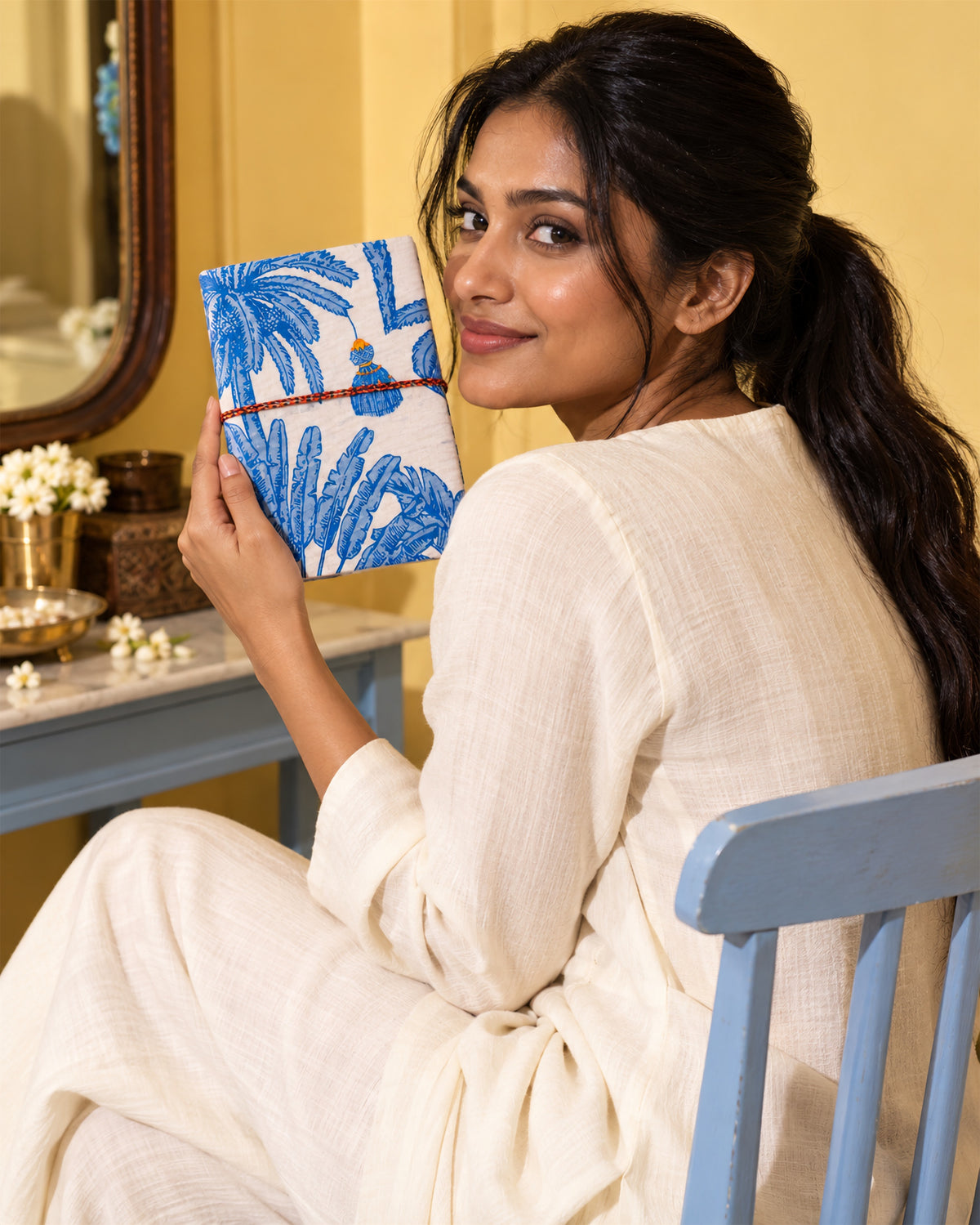 Neel Palash Block Print Fabric Diary, 200 Unruled Pages, held up over the shoulder, white outfit, mirror behind