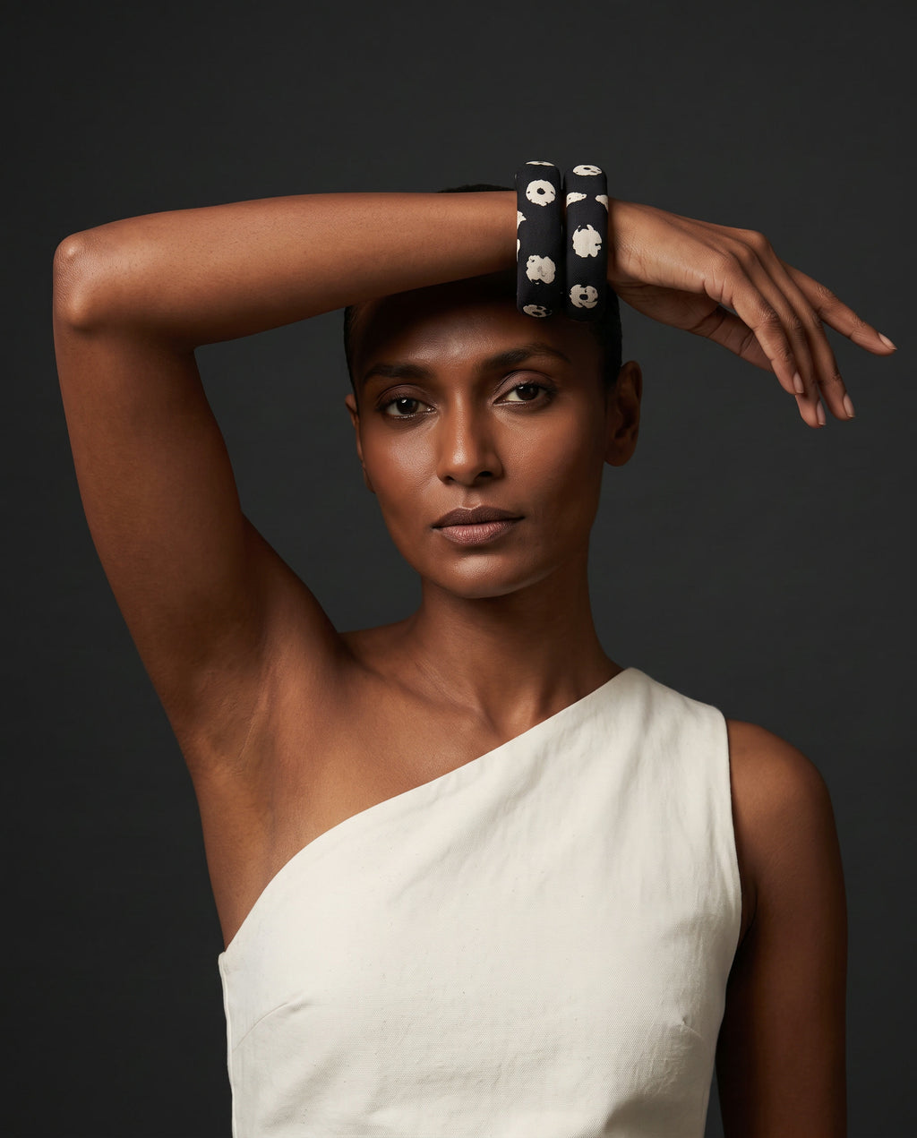 Kaali Katha black and white floral fabric bangles worn with a white one-shoulder top
