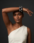 Kaali Katha black and white floral fabric bangles worn with a white one-shoulder top