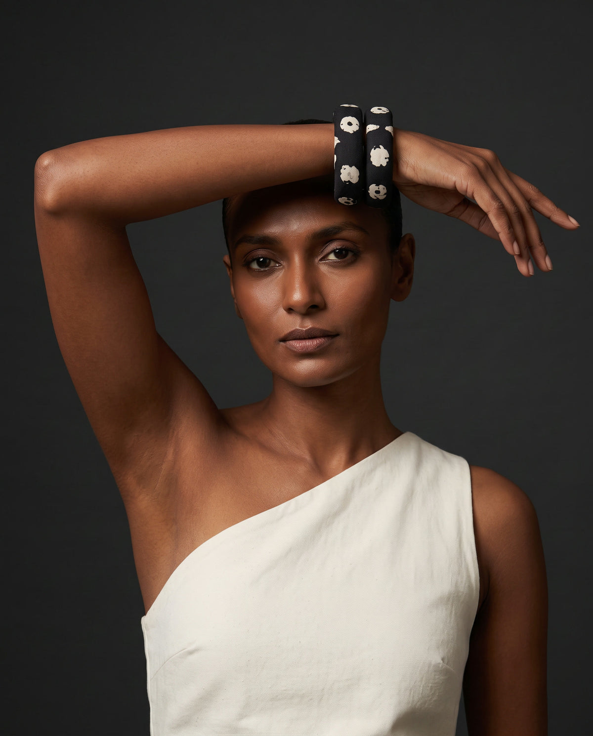 Kaali Katha black and white floral fabric bangles worn with a white one-shoulder top