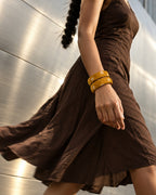 Mustard printed fabric bangles worn with a brown cotton dress