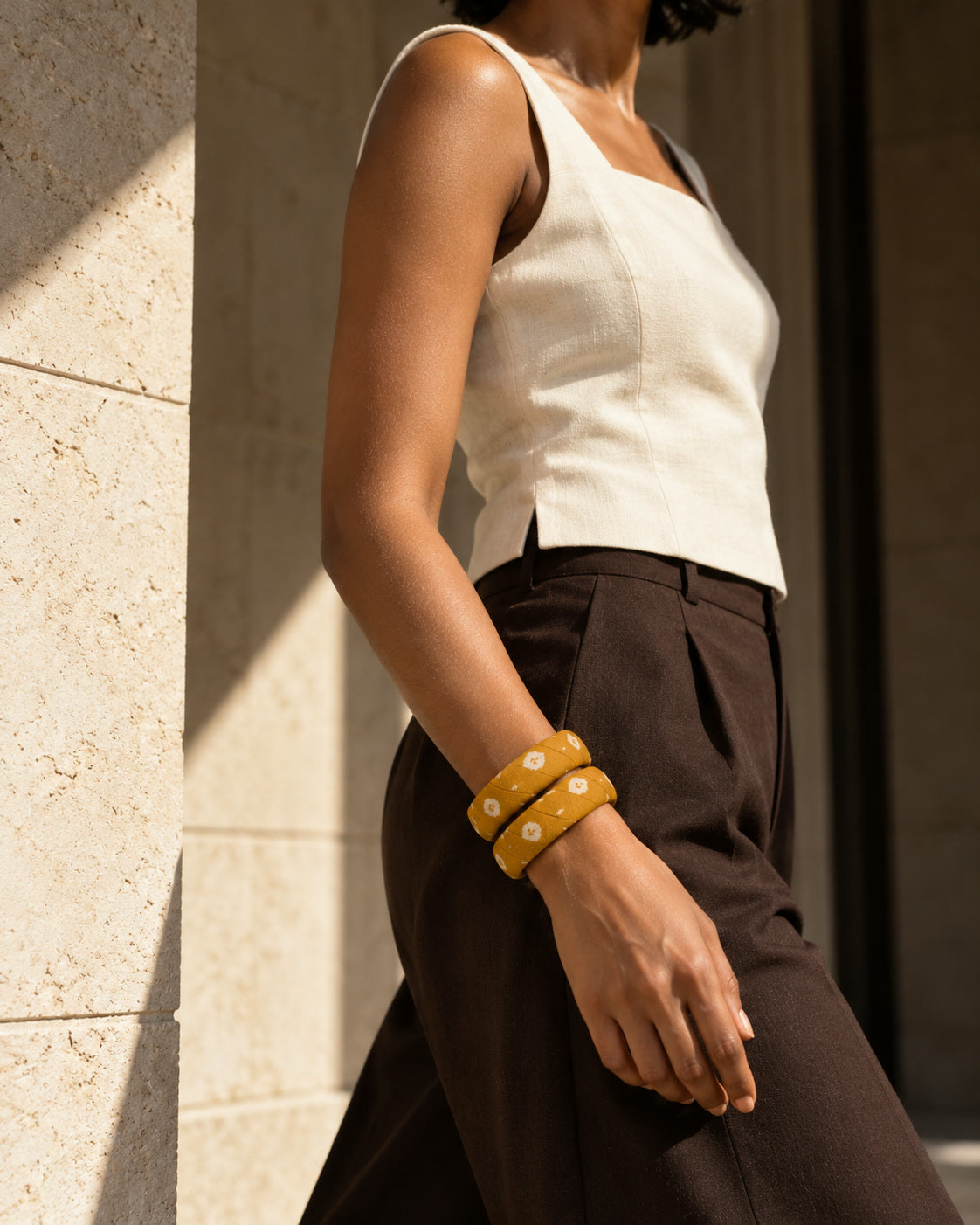 Mustard floral fabric bangles worn with a white top and brown trousers
