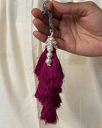 Gulabi silk tassel bag charm held in the hand to show its size, about 9 inches from clasp to fringe