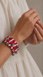 Lariya Bangles in red: leheriya fabric kada and bangles with ghungroo, shown in motion on the wrist