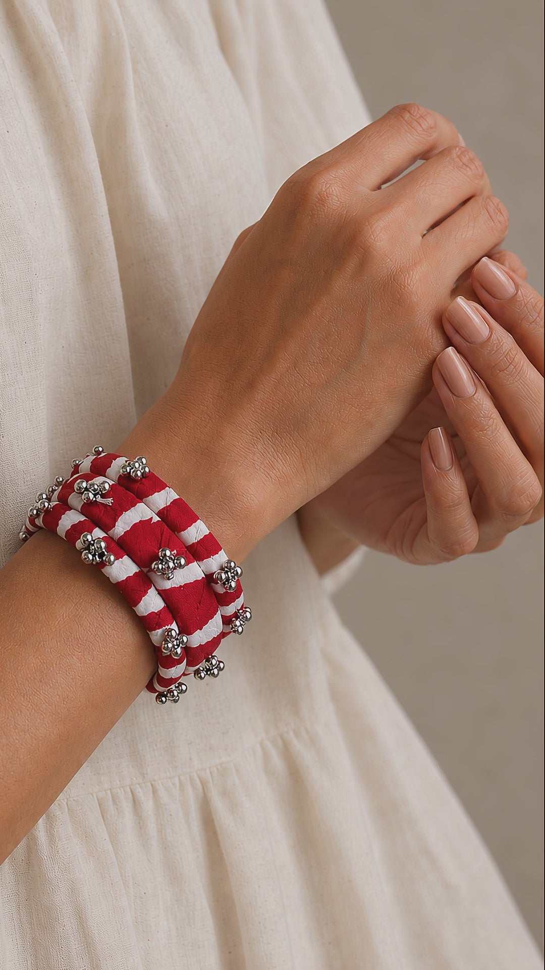 Lariya Bangles in red: leheriya fabric kada and bangles with ghungroo, shown in motion on the wrist