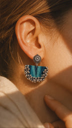 Teal green chandbali earrings, ghungroo bells swaying as the earring turns