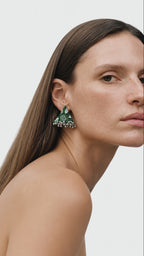Riwaayat Gulmohar green block-print triangle earring with a row of small ghungroo bells, as she closes her eyes and looks up again (AI-generated styling video)