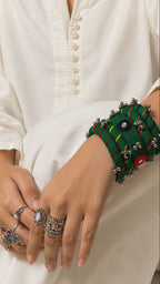 Green Rangriti fabric charm bangles with mirror work and ghungroo bells as the wrist turns slowly (AI-generated styling video)