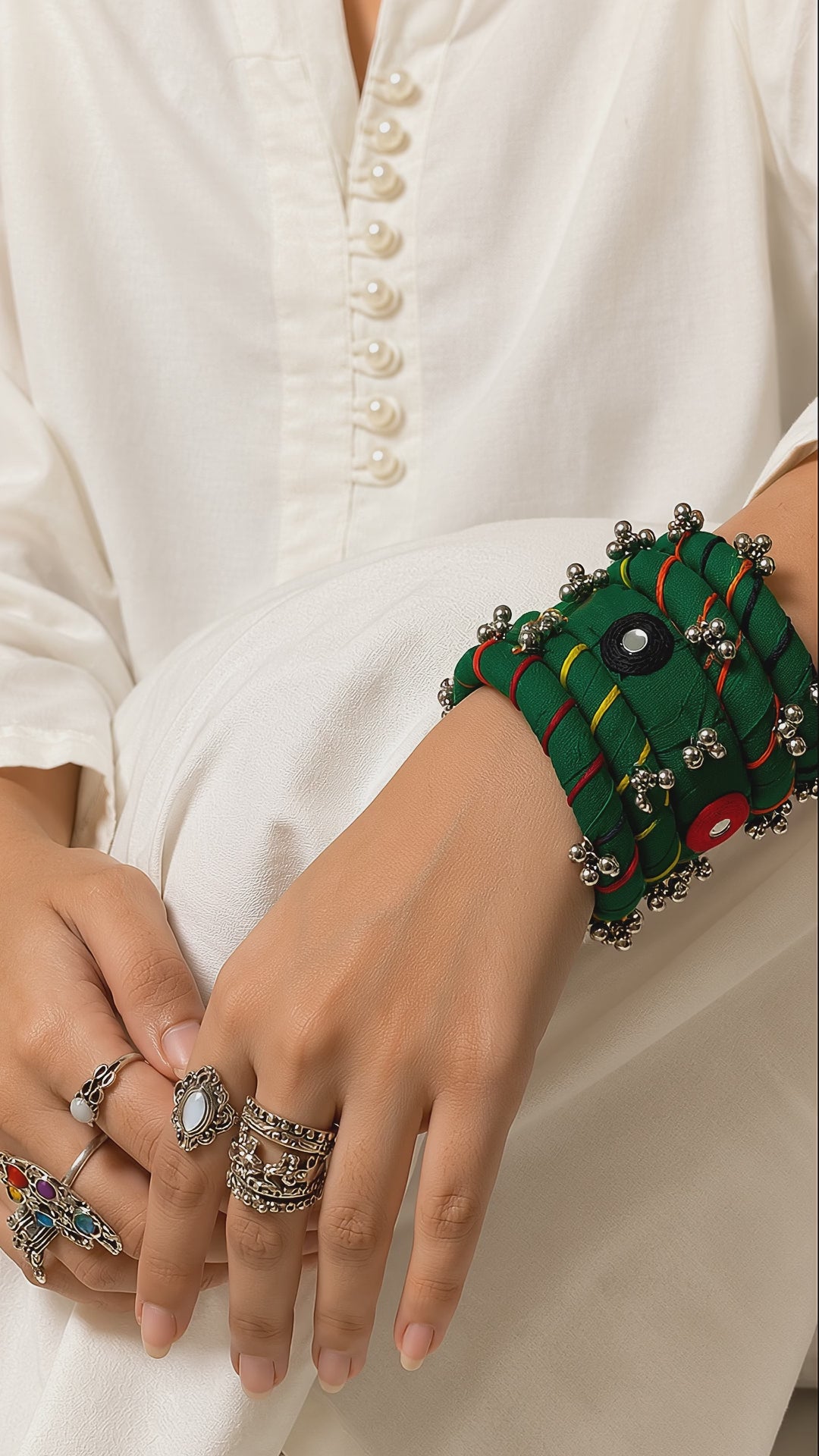 Green Rangriti fabric charm bangles with mirror work and ghungroo bells as the wrist turns slowly (AI-generated styling video)