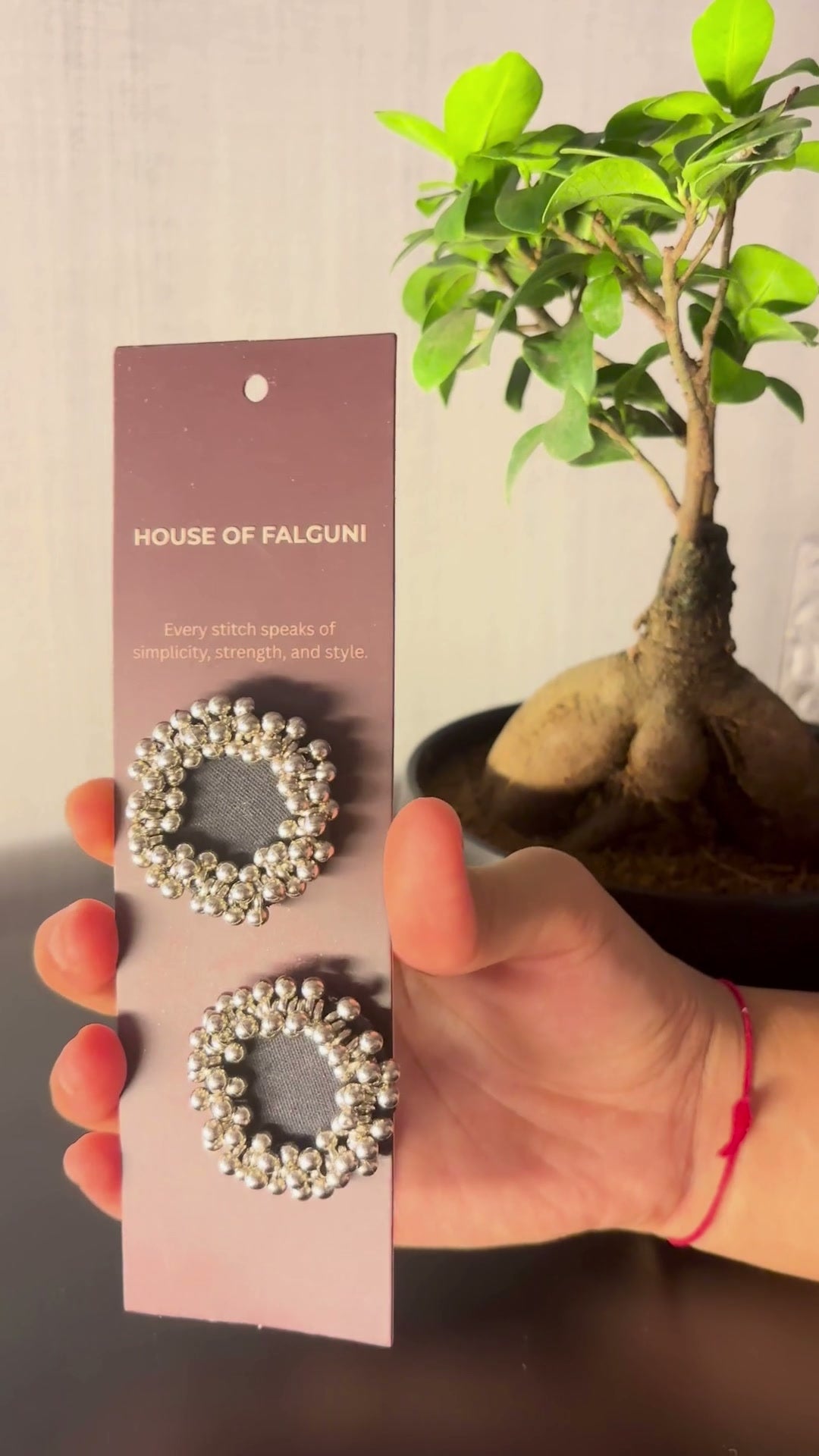 Charcoal Ghungroo Stud Earrings: Charcoal Ghungroo Stud Earrings on a House of Falguni card, brought up close: charcoal cotton centre ringed with two rows of ghungroo bells