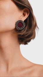 Maroon ghungroo stud earrings ringed with tiny silver bells, worn as the model slowly turns her head (AI-generated styling video)