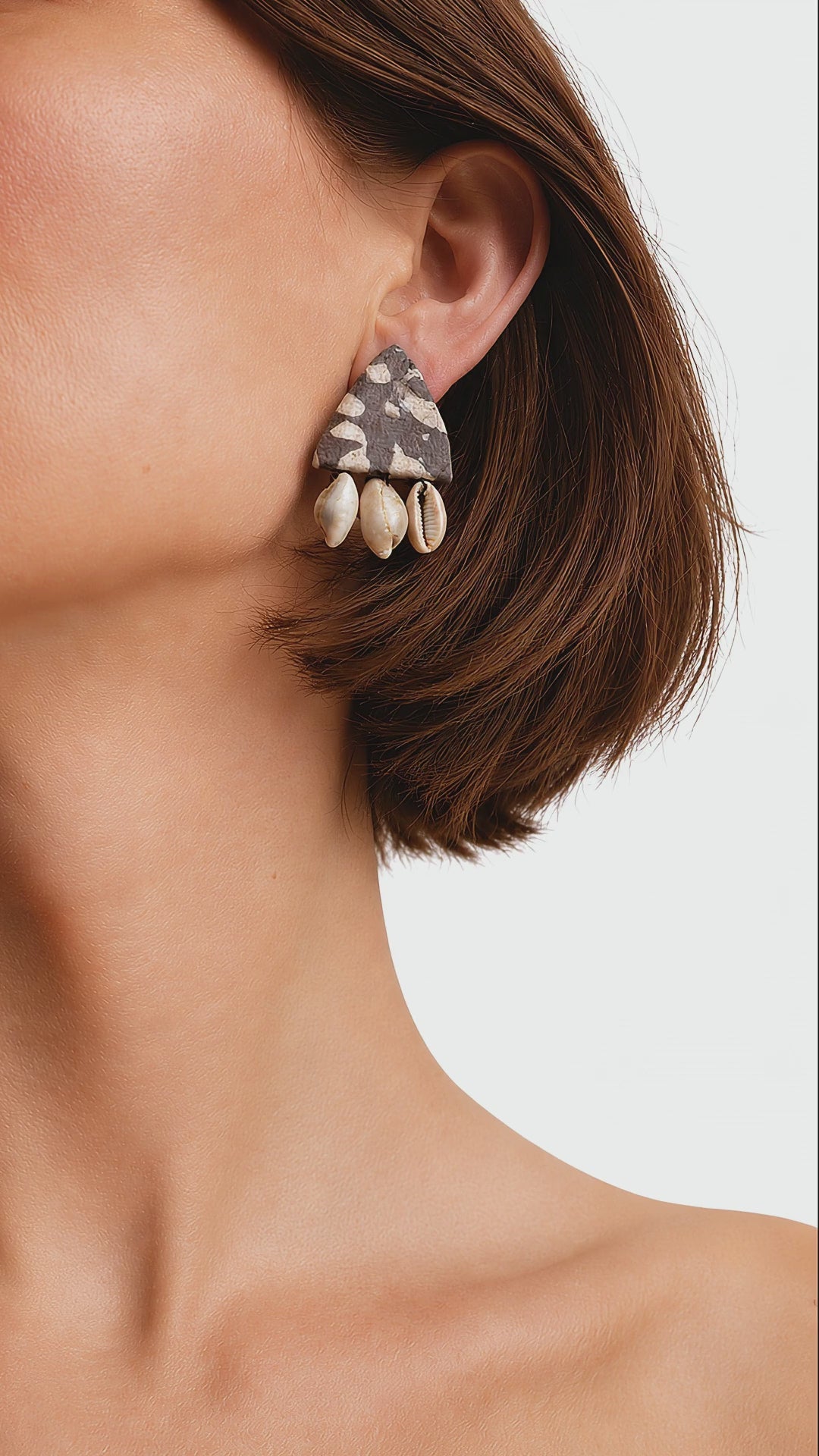 Shell Saga printed fabric earring with small natural cowrie shells swaying gently below the ear (AI-generated styling video)