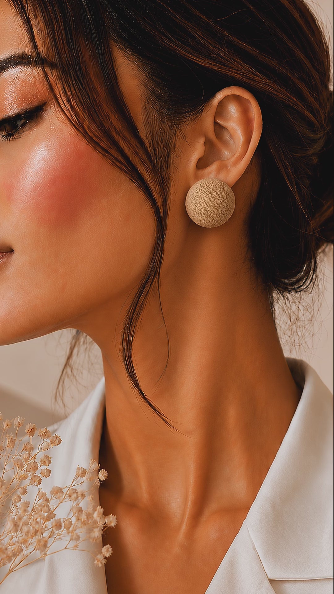 Ibrik Accents cream round fabric stud earrings worn by a model slowly turning her head