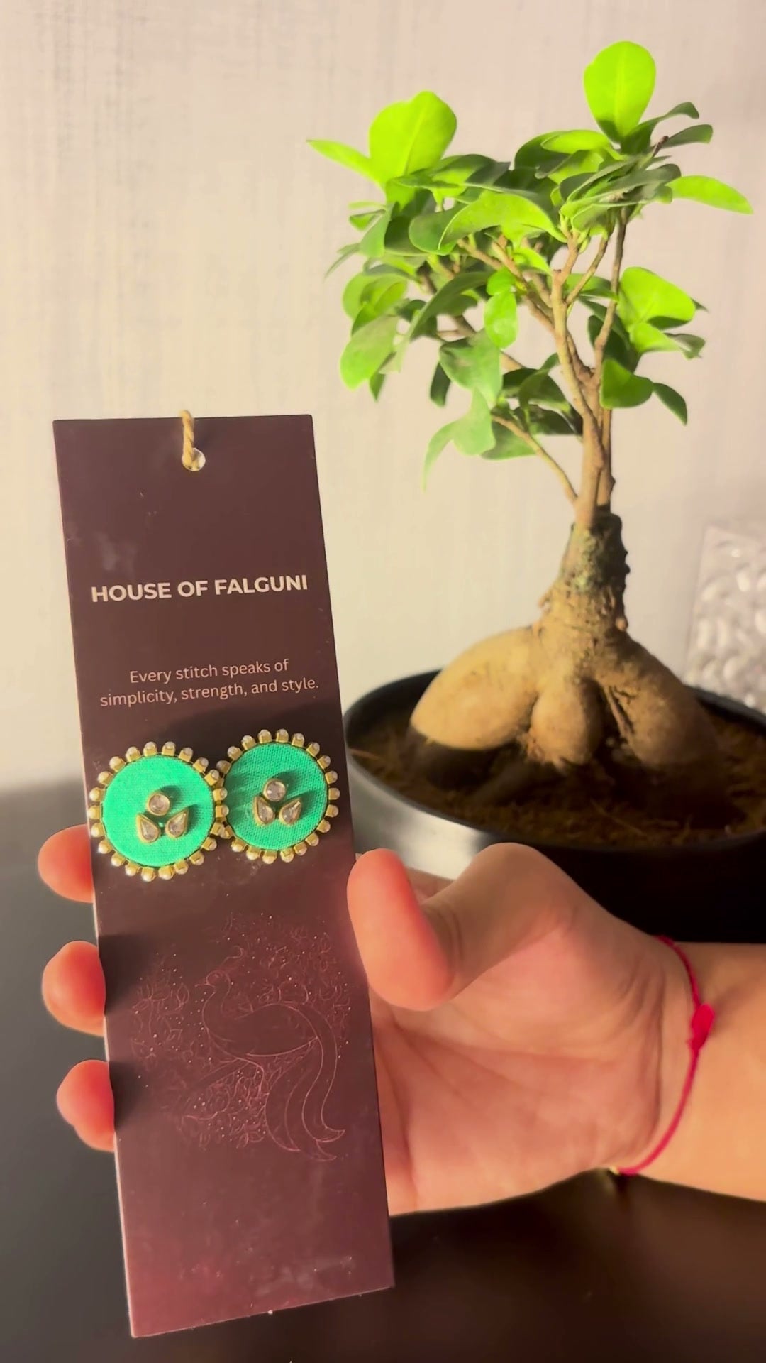 Mogra Mint Green Round Kundan Studs: Mogra Mint Green Round Kundan Studs on a House of Falguni card, tilted in the light: mint green round fabric studs with three kundan stones and a small kundan border