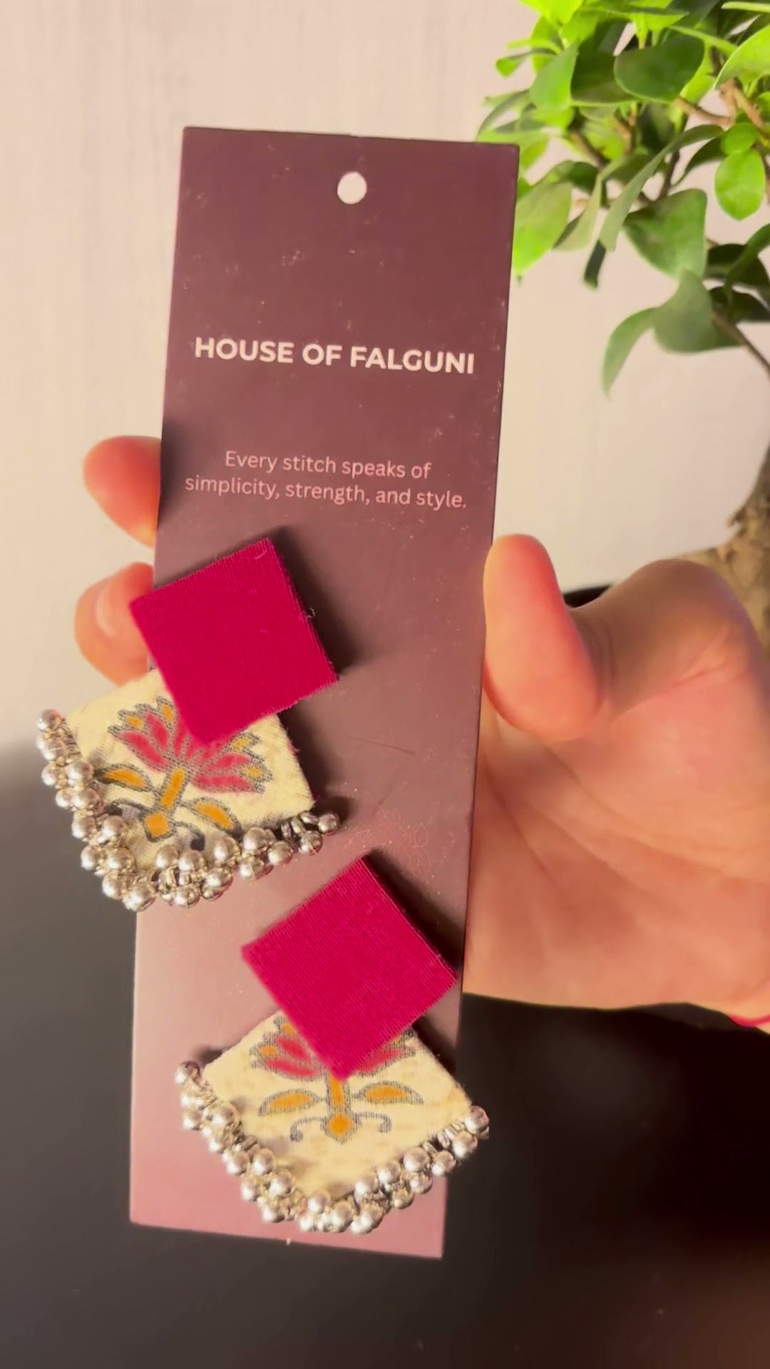 Fuchsia Floral Geometric Ghungroo Earrings: Fuchsia Floral Geometric Ghungroo earrings on a House of Falguni card, brought up close: fuchsia square stud over a cream floral fabric diamond edged with ghungroo bells