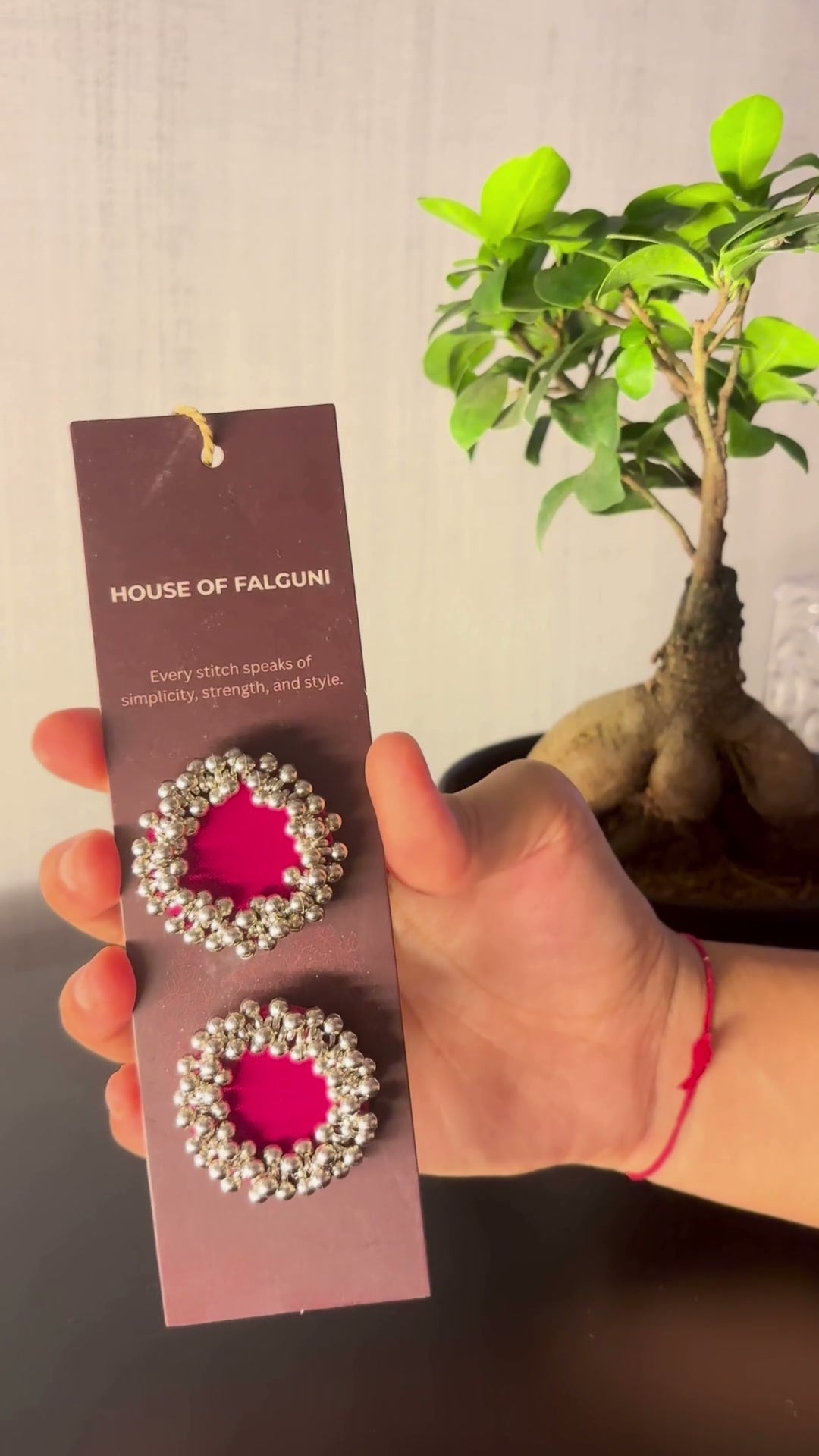 Fuchsia Pink Ghungroo Stud Earrings: Fuchsia Pink Ghungroo Stud Earrings on a House of Falguni card, brought up close: fuchsia cotton centre ringed with two rows of ghungroo bells