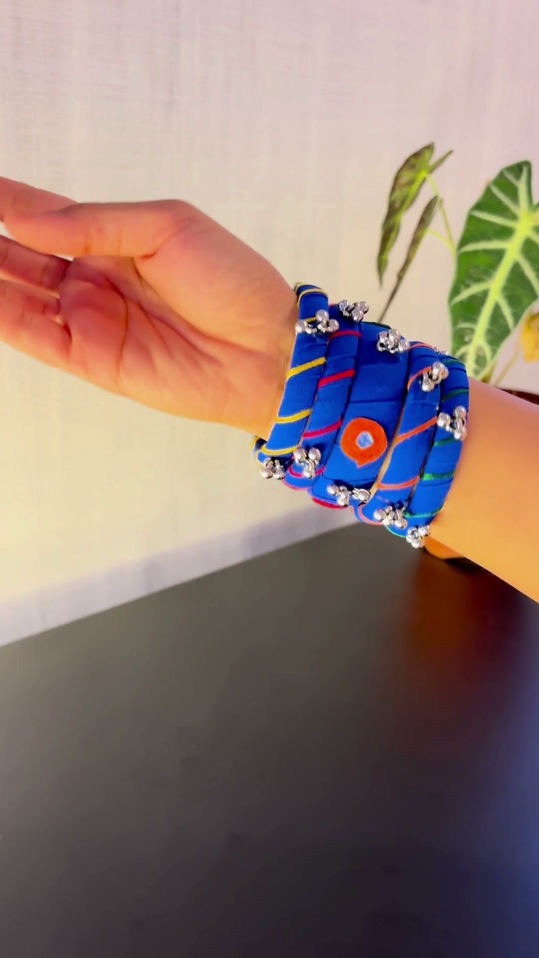 Rangriti Blue Mirror Work Bangles with Ghungroo, Kada Set of 5: Rangriti Blue mirror work bangles with ghungroo: the kada and four bangles turned in the hand, then slipped onto the wrist one by one