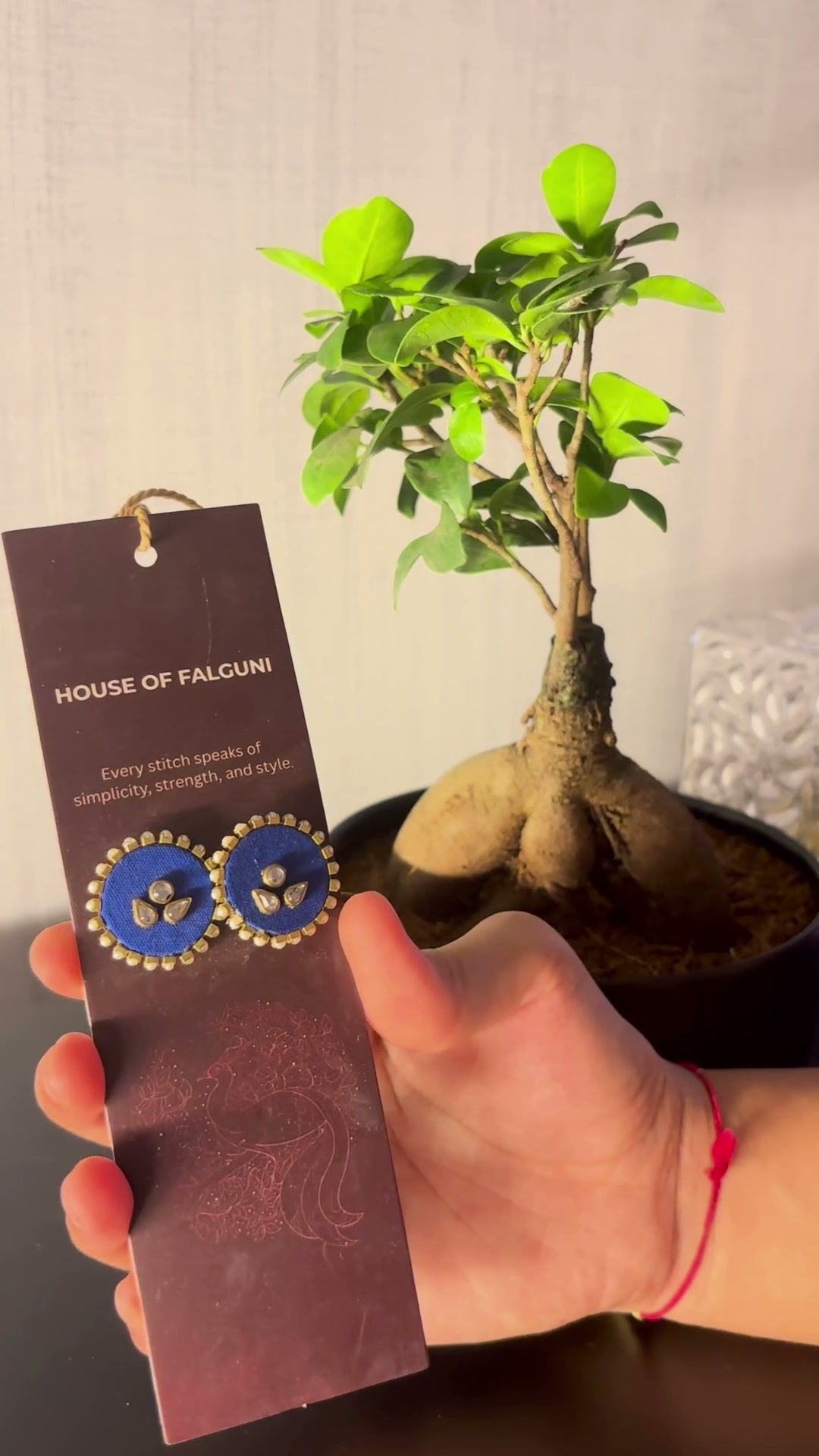 Mogra Royal Blue Round Kundan Studs: Mogra Royal Blue Round Kundan Studs on a House of Falguni card, tilted in the light: royal blue round fabric studs with three kundan stones and a small kundan border