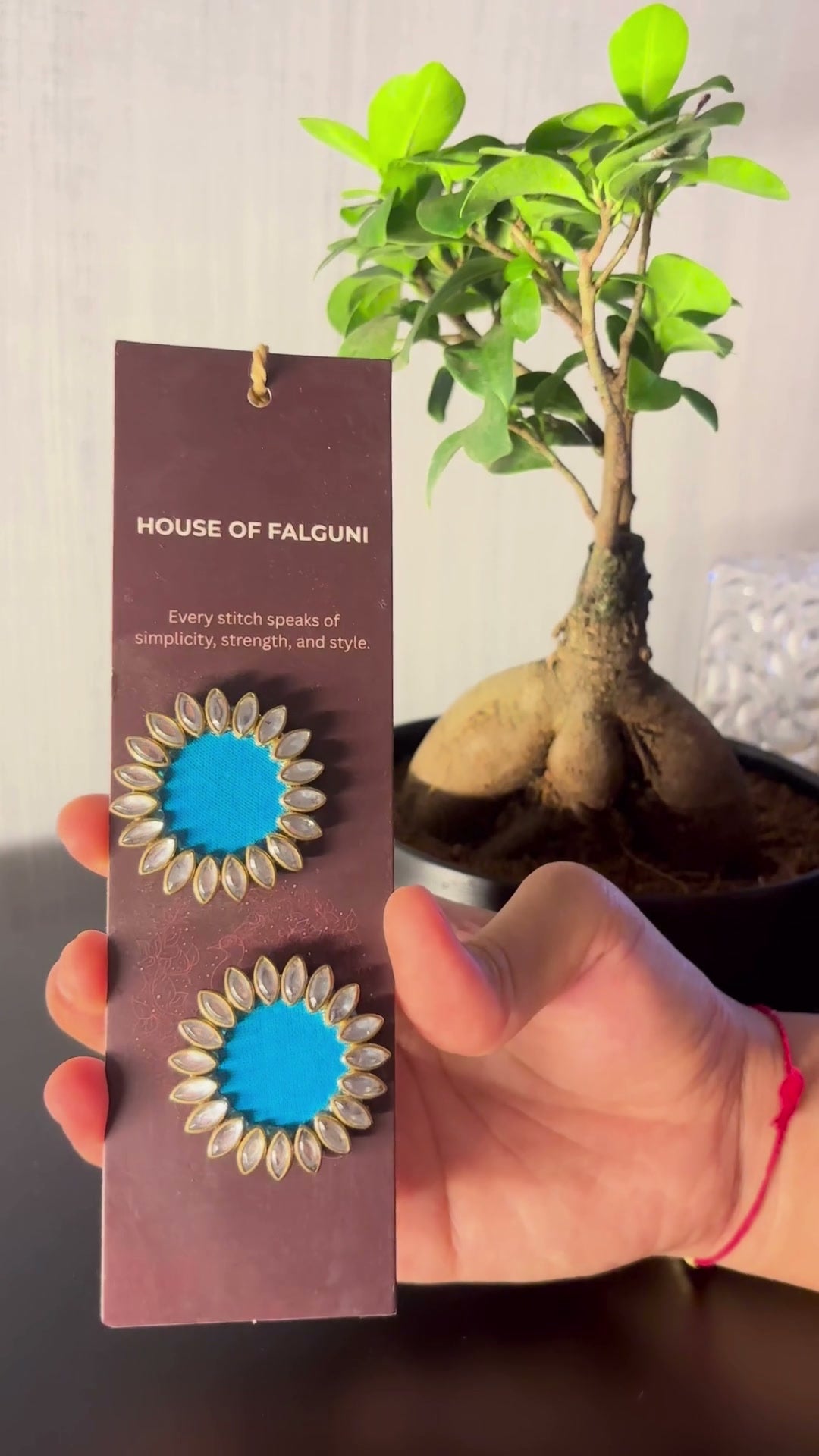 Sky Blue Floral Kundan Earrings: Sky Blue Floral Kundan Earrings on a House of Falguni card, tilted in the light: pointed kundan petals around bright sky blue fabric centres