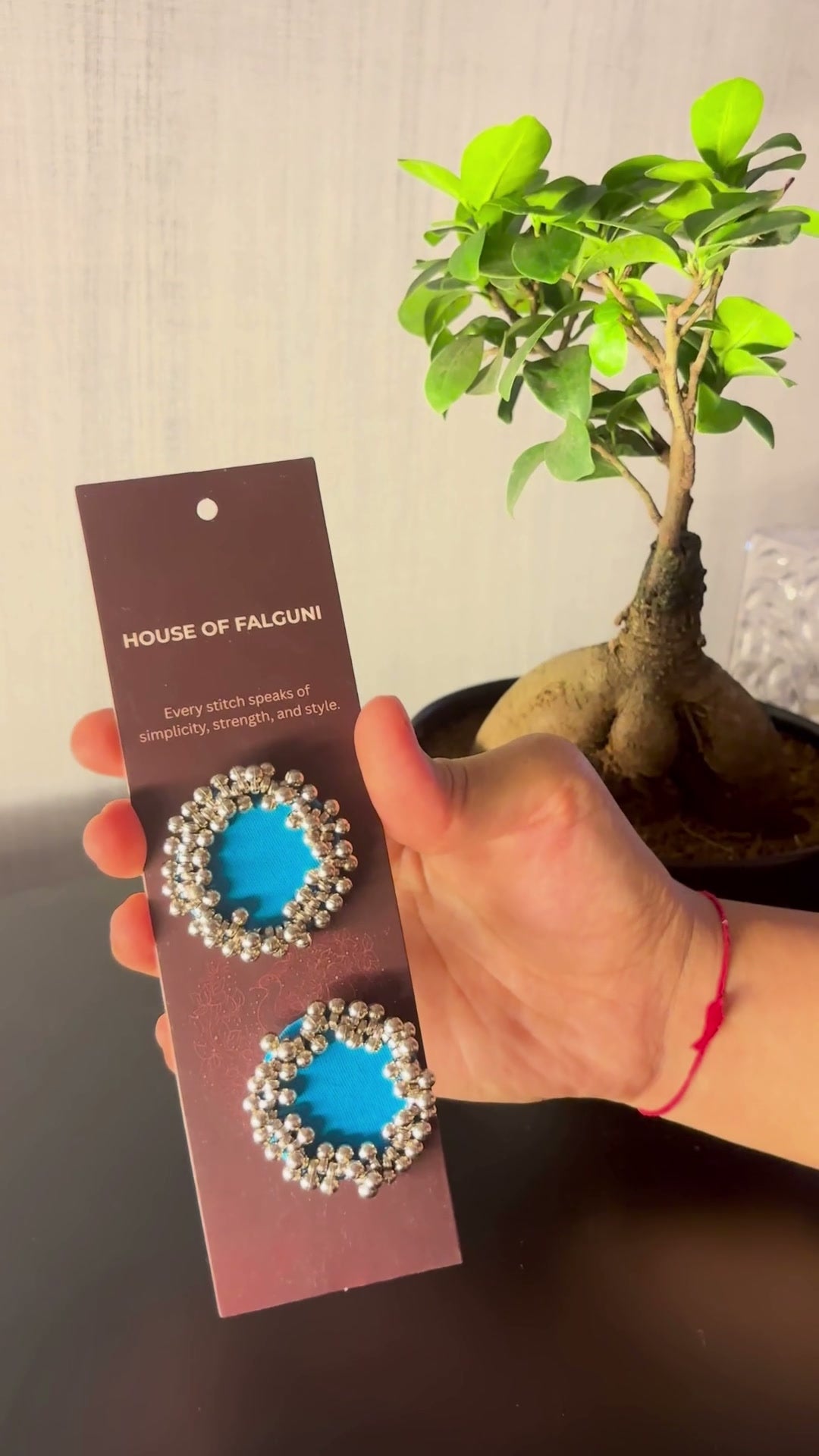 Sky Blue Ghungroo Stud Earrings: Sky Blue Ghungroo Stud Earrings on a House of Falguni card, brought up close: sky blue cotton centre ringed with two rows of ghungroo bells