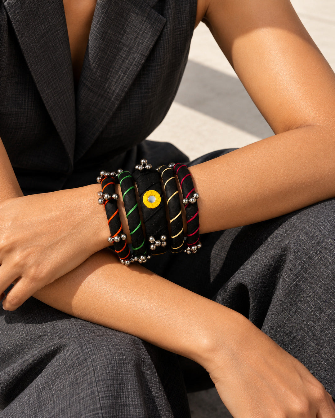Rangriti black fabric kada and four bangles with mirror work and ghungroo, worn by model with crossed forearms (AI-generated styling image)
