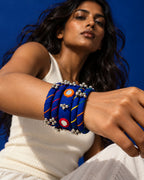 Rangriti blue fabric kada and four bangles with mirror work and ghungroo, worn by model in an ivory top (AI-generated styling image)
