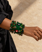 Rangriti green fabric kada and four bangles with mirror work and ghungroo, close-up on a model’s wrist (AI-generated styling image)