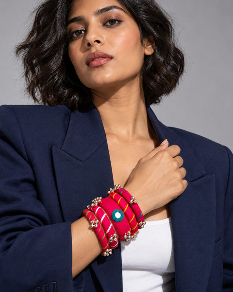 Rangriti pink fabric kada and four bangles with mirror work and ghungroo, worn by model in a navy blazer (AI-generated styling image)