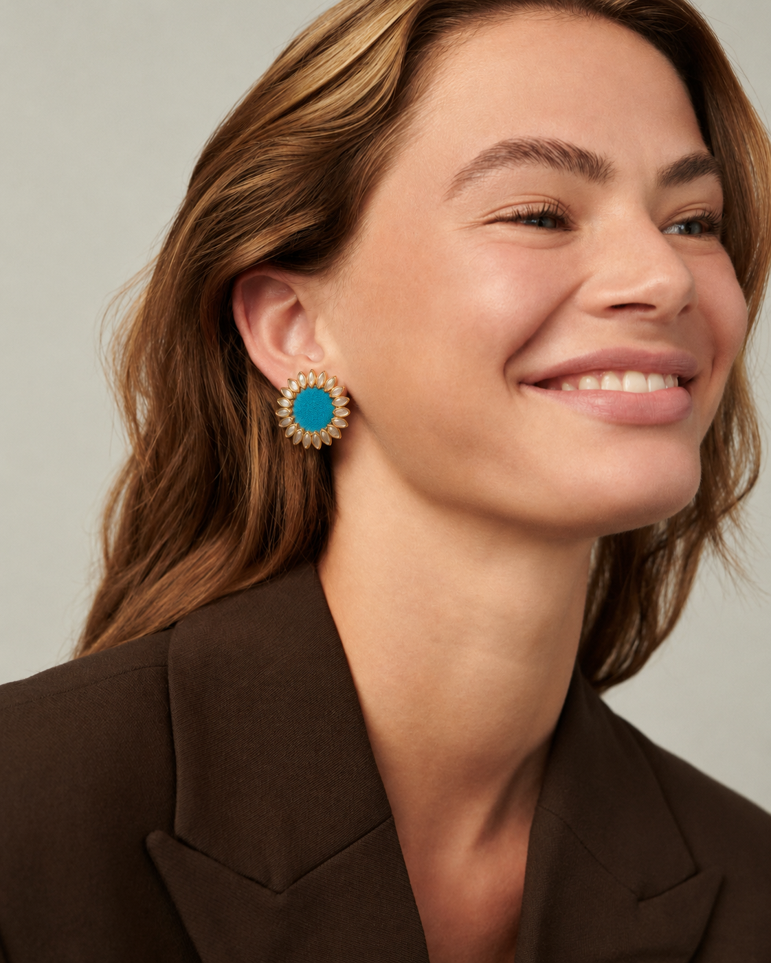 Sky Blue Floral Kundan Earrings worn with a brown blazer: a small kundan sunflower with a blue fabric centre, sitting on the earlobe
