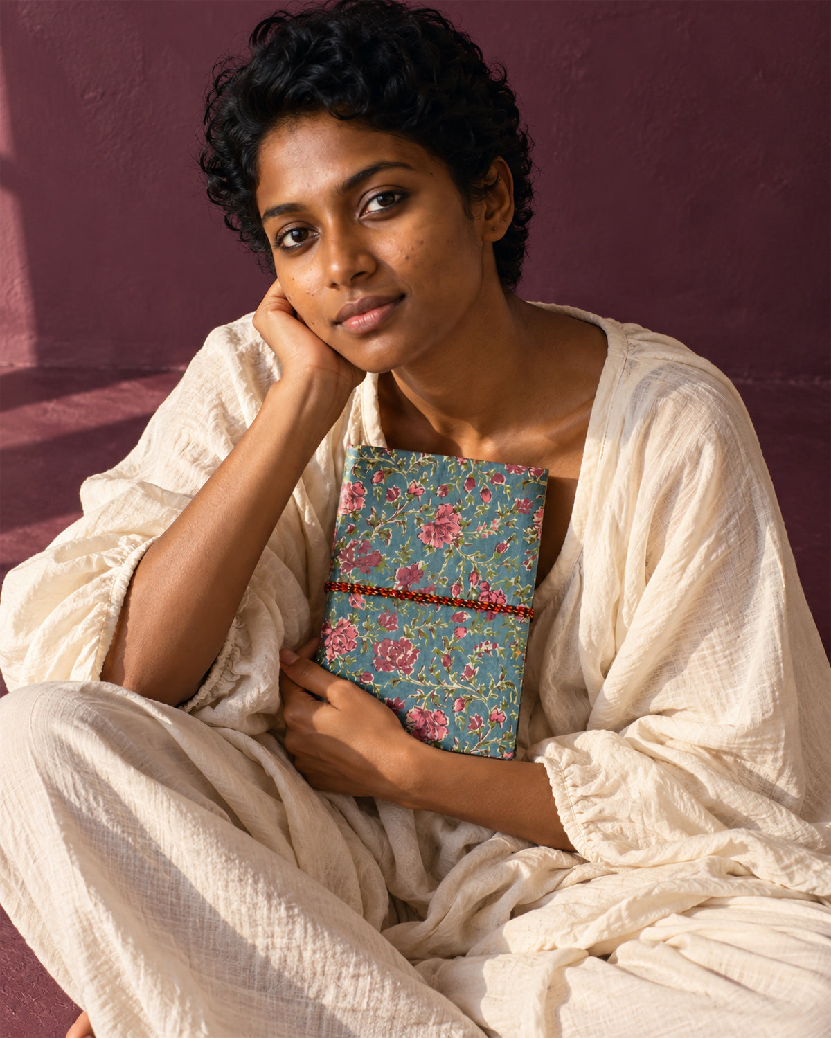 Slate Rose Block Print Fabric Diary, 200 Unruled Pages, held at the chest, white outfit, warm grey wall