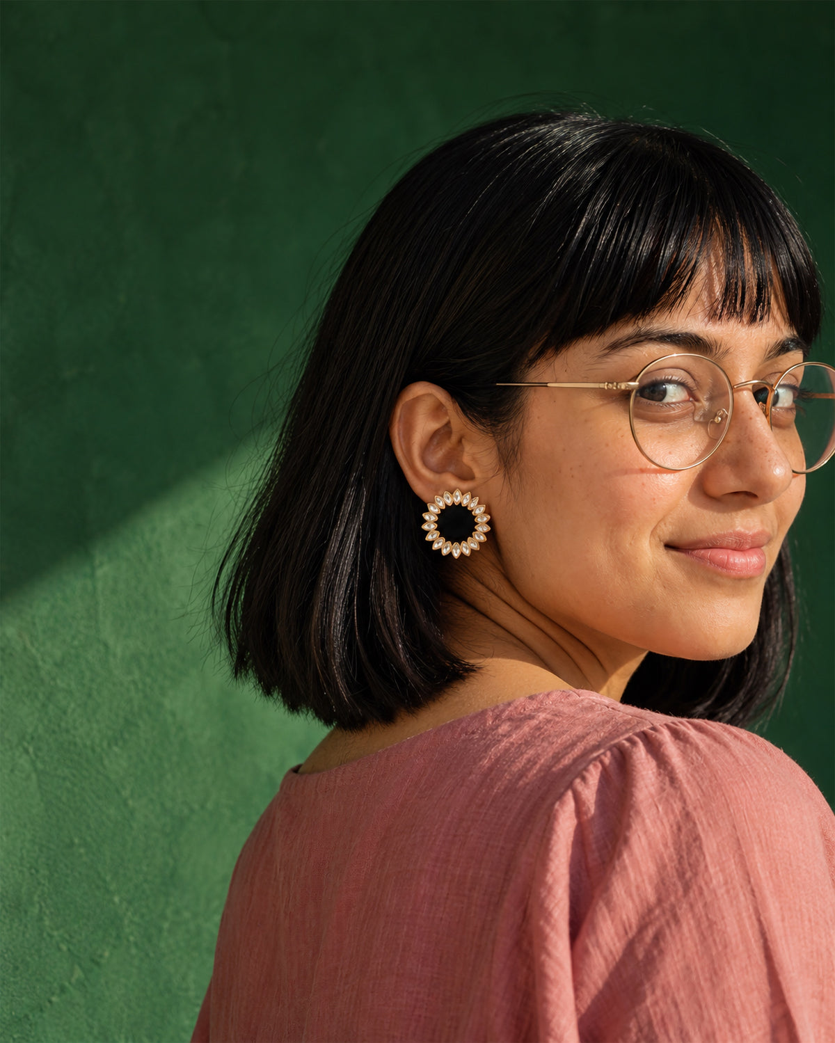 Black Floral Kundan Earrings, worn, round glasses, pink top, deep emerald wall